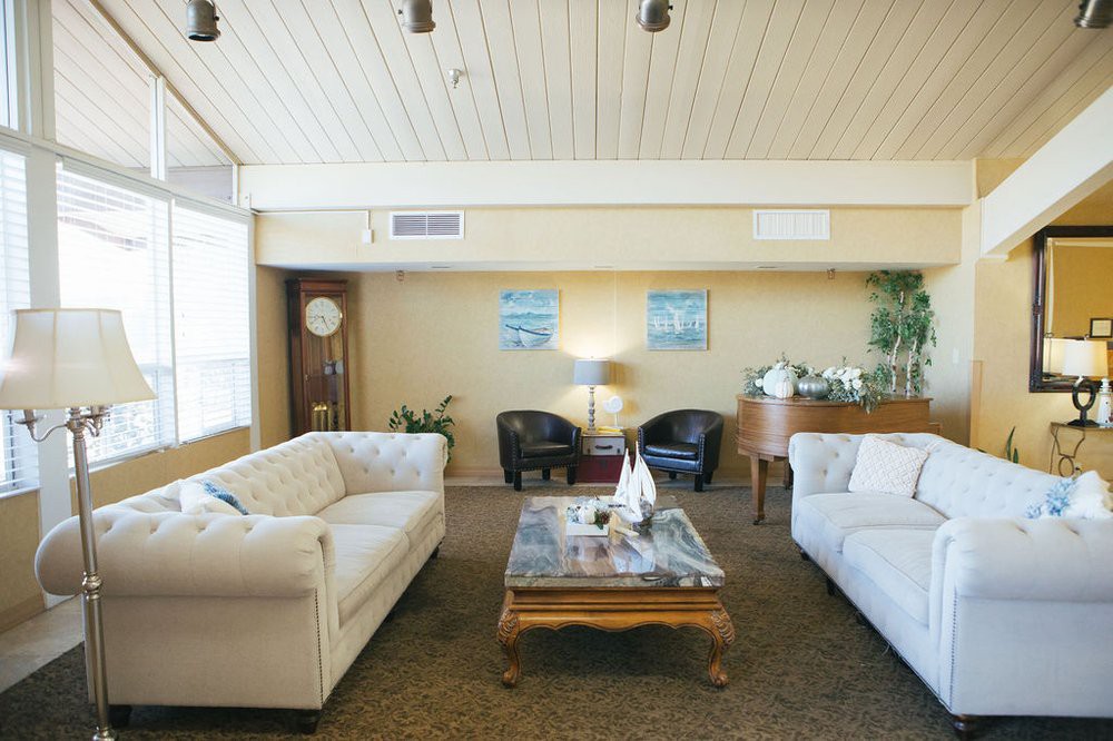 A cozy living room with white sofas, a wooden coffee table, and modern decor.