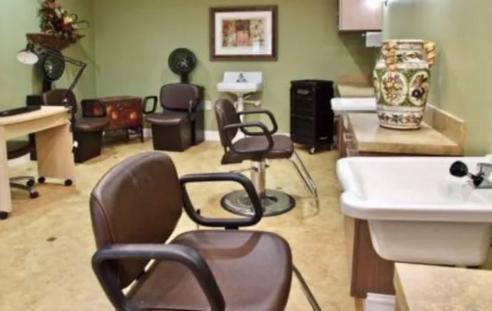 An interior view of a hair salon with empty chairs and beauty equipment.