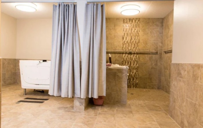A modern bathroom featuring a shower area with elegant tiles and curtains.