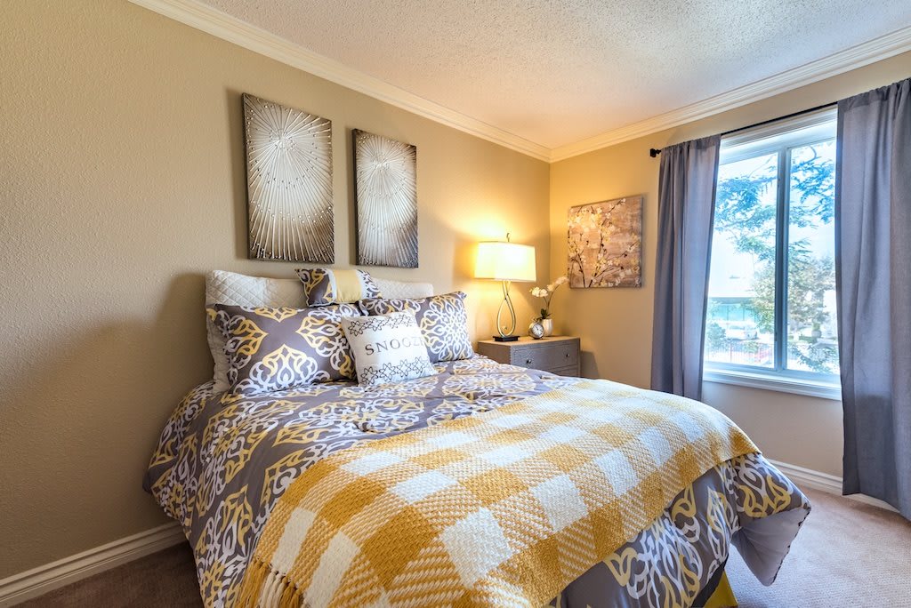 A cozy bedroom with warm lighting and patterned bedding.
