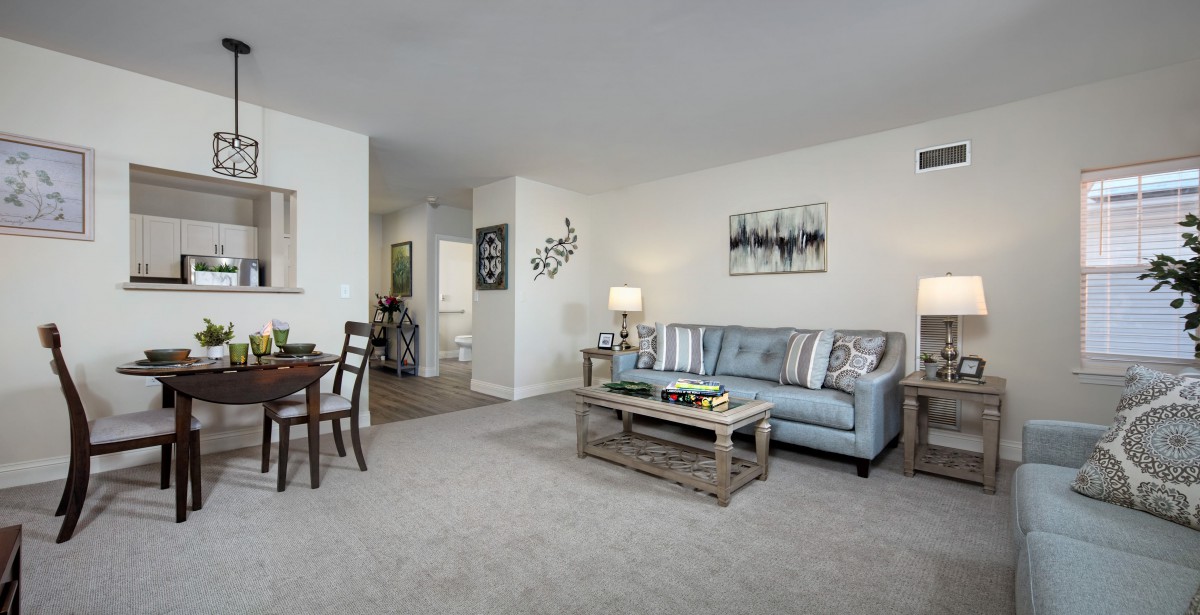 A modern living room with a cozy sofa, coffee table, and an adjacent dining area.