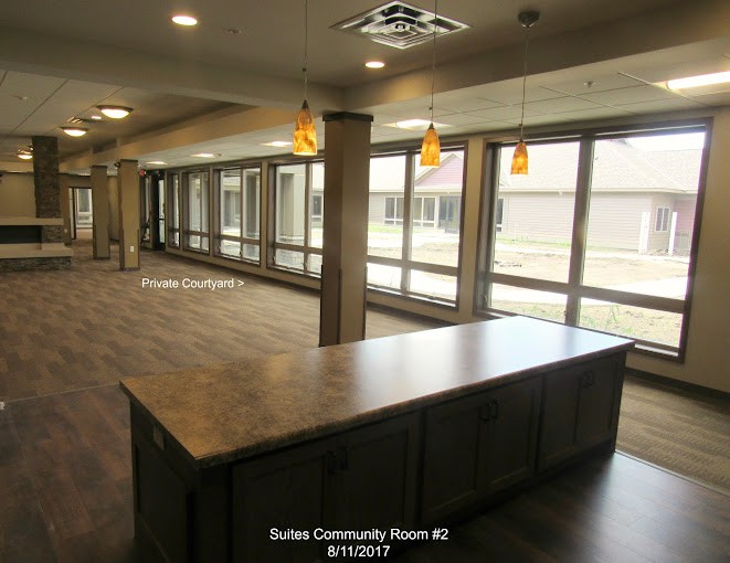A modern community room with large windows and ample natural light.
