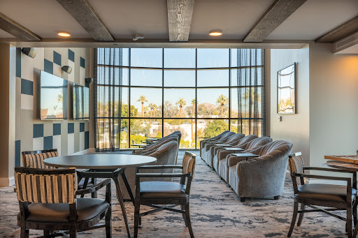 A contemporary lounge area featuring comfortable seating and large windows that let in ample natural light.