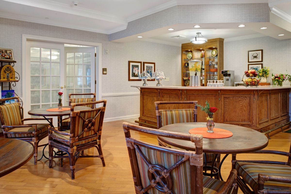A cozy dining area with wooden tables, chairs, and a bar counter.