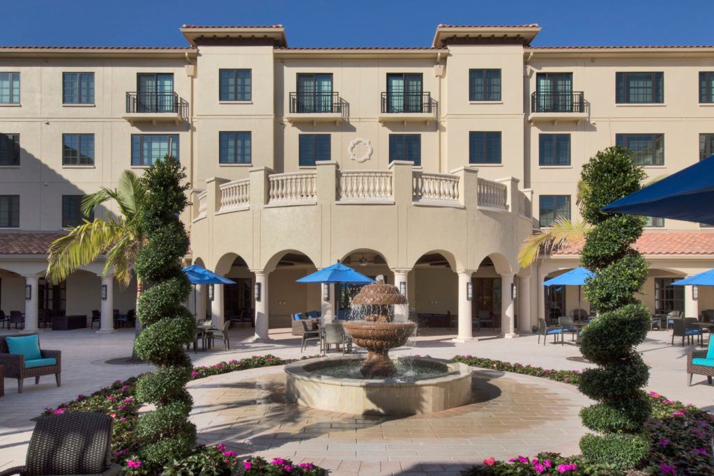 A luxurious hotel with a central fountain and outdoor seating area.