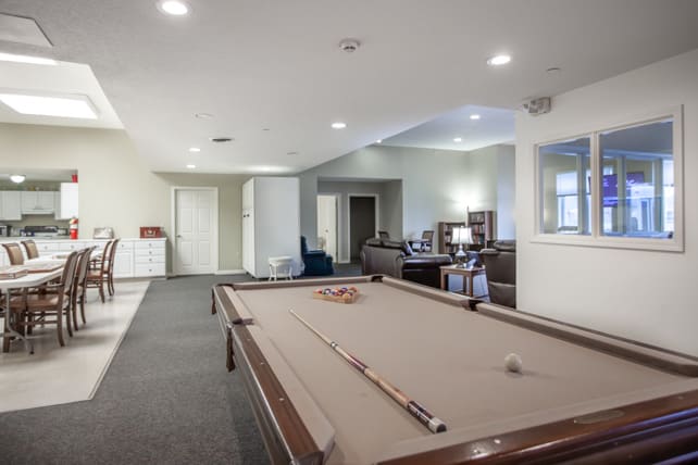 A spacious game room featuring a pool table and comfortable seating for relaxation.
