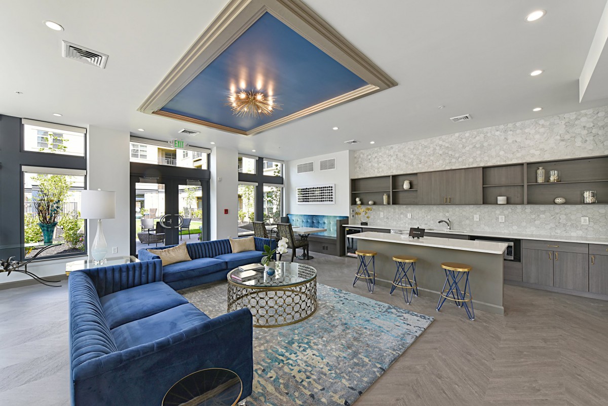 A modern, open-concept living room featuring a blue color scheme and luxury decor.