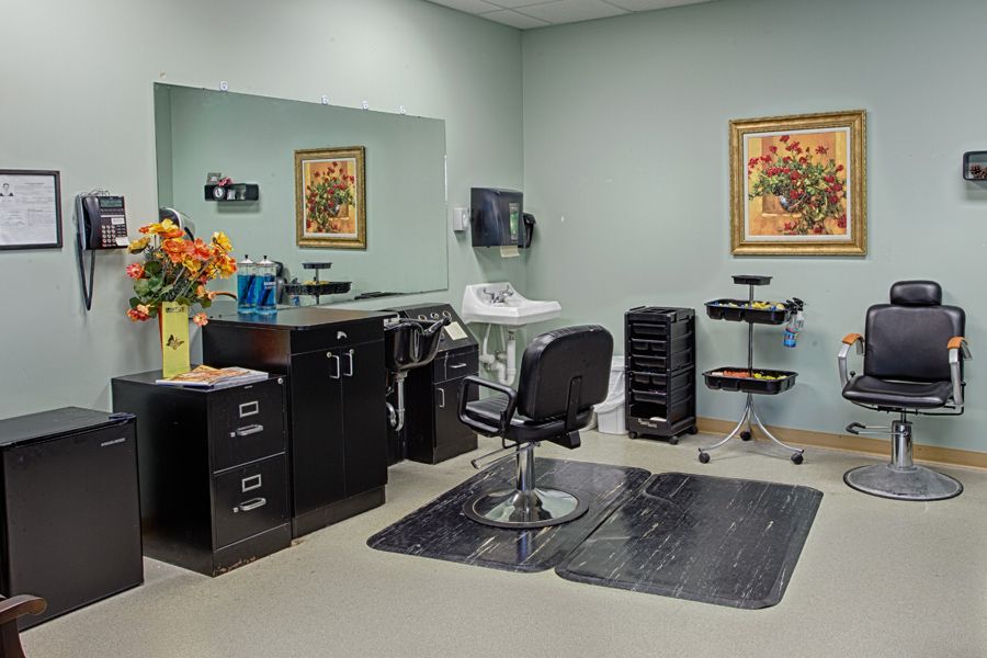 A tidy and well-equipped hair salon interior with a styling chair, mirror, and salon tools.