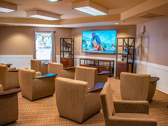 A cozy lounge area with comfortable seating and a large television.