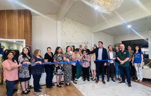 A vibrant gathering celebrating the grand opening of a new business with a ribbon-cutting ceremony.