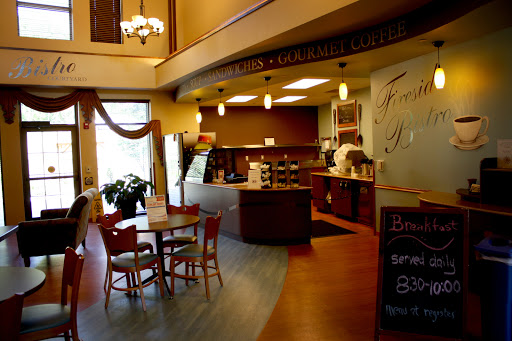 A cozy caf interior featuring a service counter, seating area, and warm lighting.
