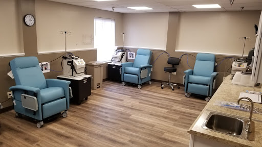 A modern treatment room equipped with comfortable chairs and healthcare equipment for patient care.