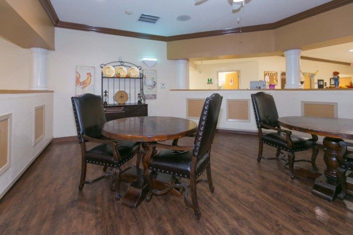 A cozy dining area with wooden tables and chairs, featuring elegant decor and warm lighting.