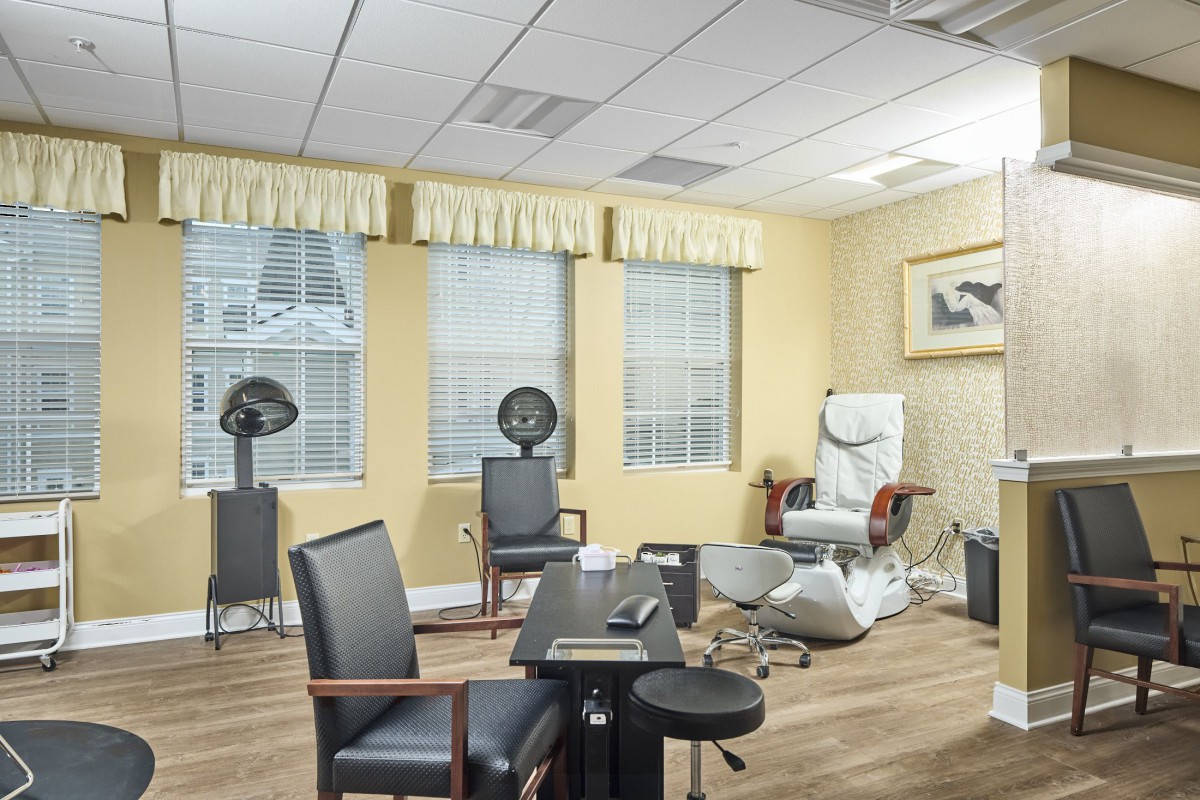 A well-lit salon interior with modern furniture and hair drying stations.