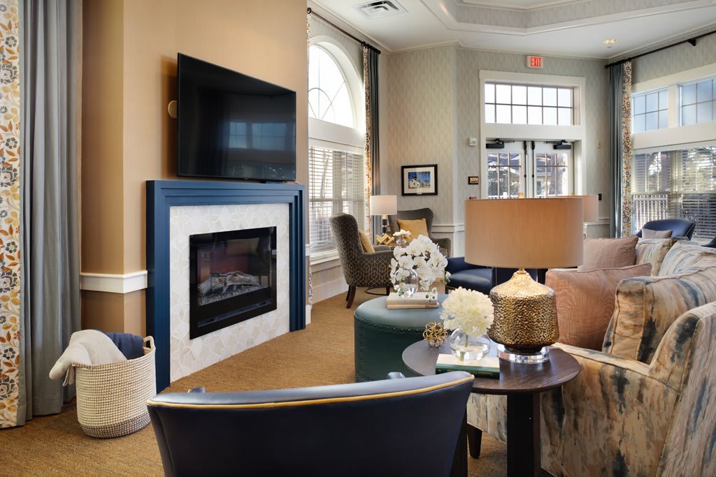 A cozy living room featuring a fireplace and television, surrounded by comfortable seating and stylish decor.