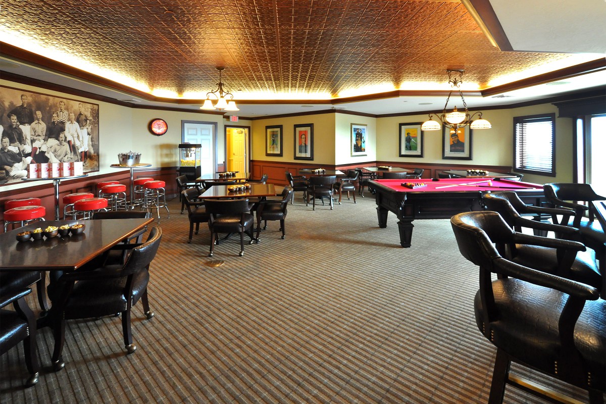 A spacious game room featuring pool tables and comfortable seating.