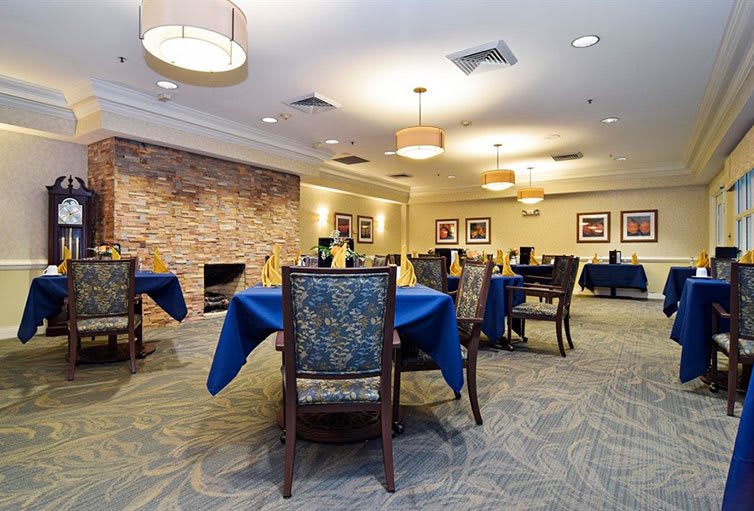 An elegantly decorated dining room with tables and chairs, featuring warm lighting and a cozy atmosphere.