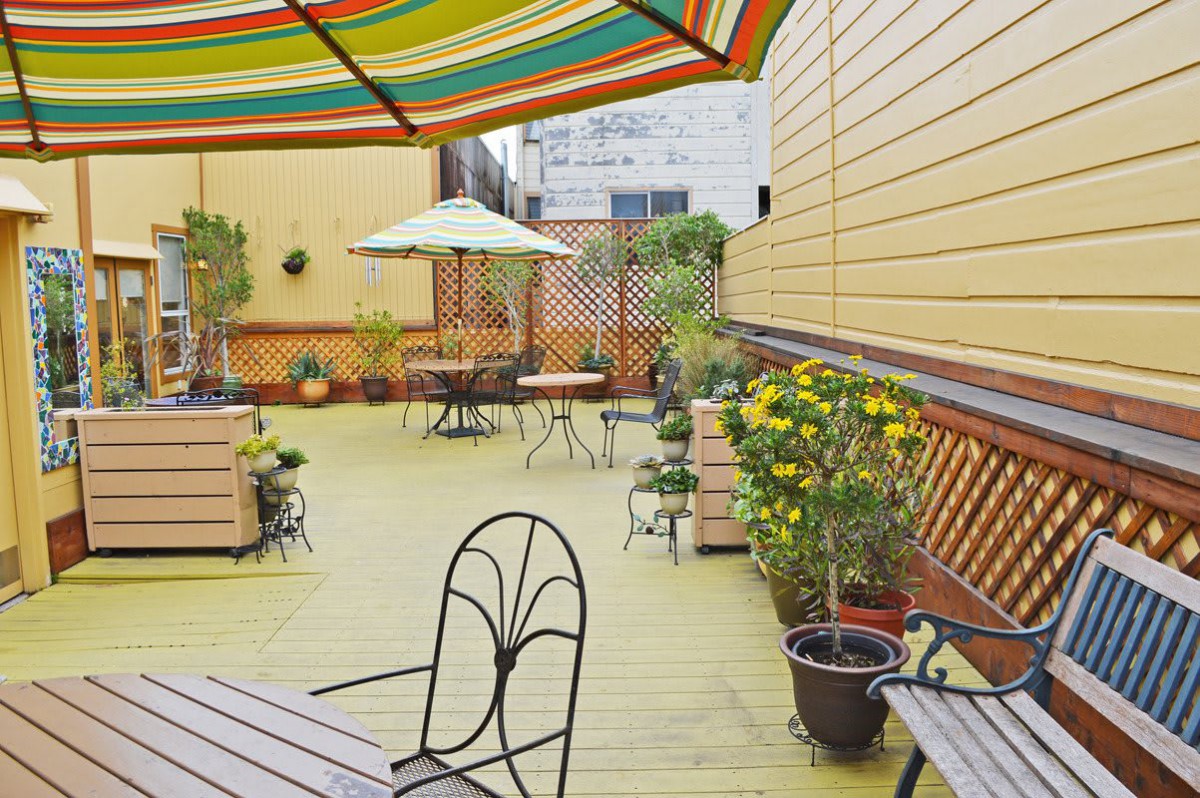 A cozy patio with colorful umbrellas and potted plants, perfect for outdoor relaxation.