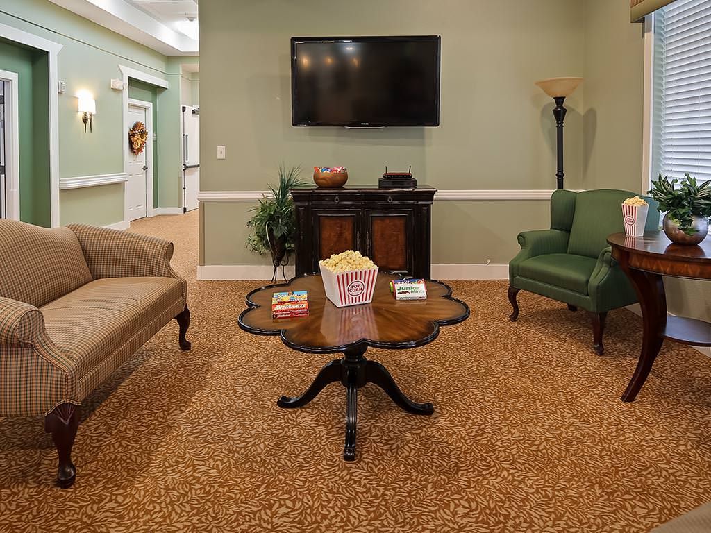 A cozy living room setup with a sofa, armchair, coffee table, and television.
