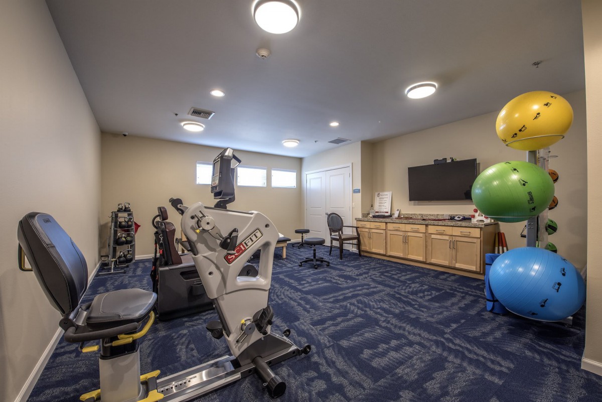 A well-equipped exercise room featuring stationary bikes and therapy balls.