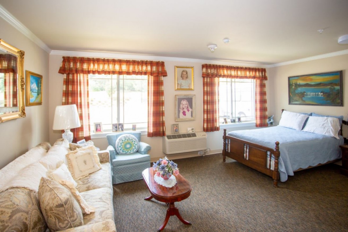 A cozy bedroom with vintage-style furniture and ample natural light streaming through the windows.