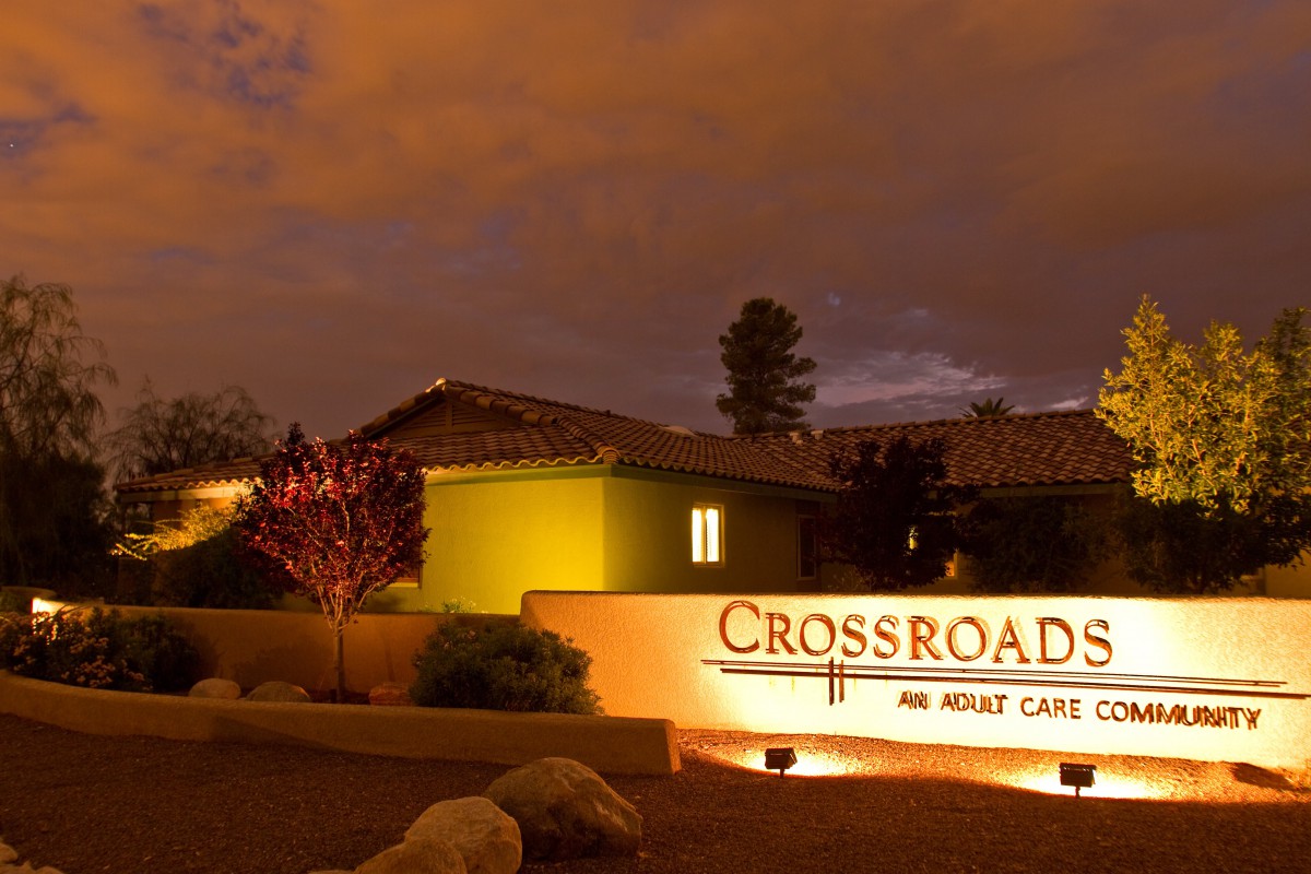 Night view of a building with illuminated sign reading 'Crossroads Adult Care'.