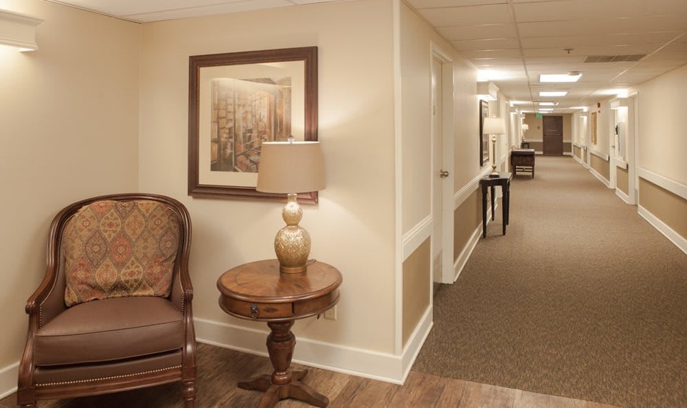 A warmly lit hallway with elegant furnishings and artwork on the walls.