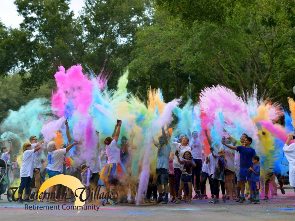 Participants throw colorful powders during an outdoor color run event.
