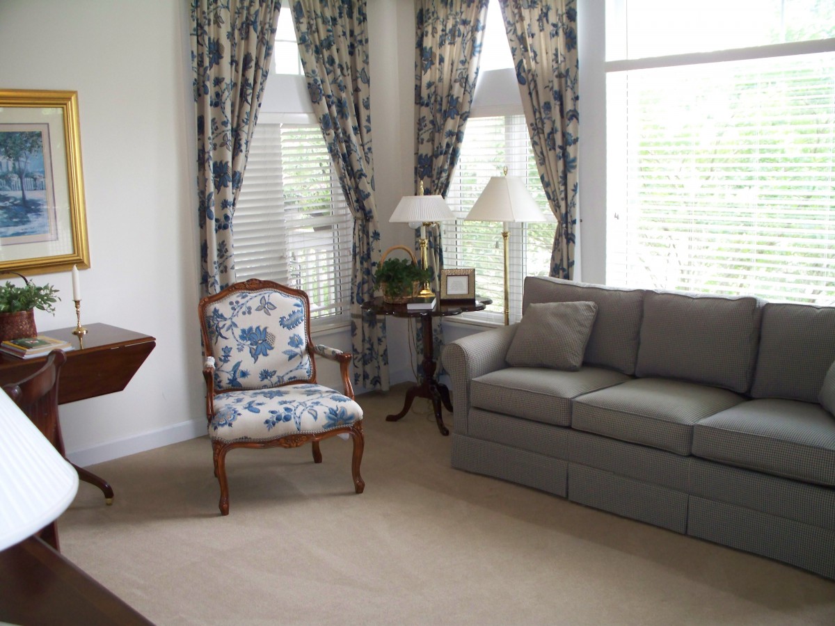 Elegantly decorated living room with a comfortable couch and floral armchair.