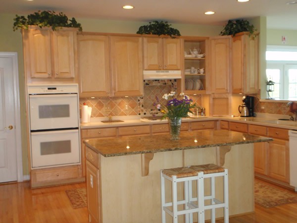 A modern kitchen with wooden cabinets, a central island, and built-in appliances.