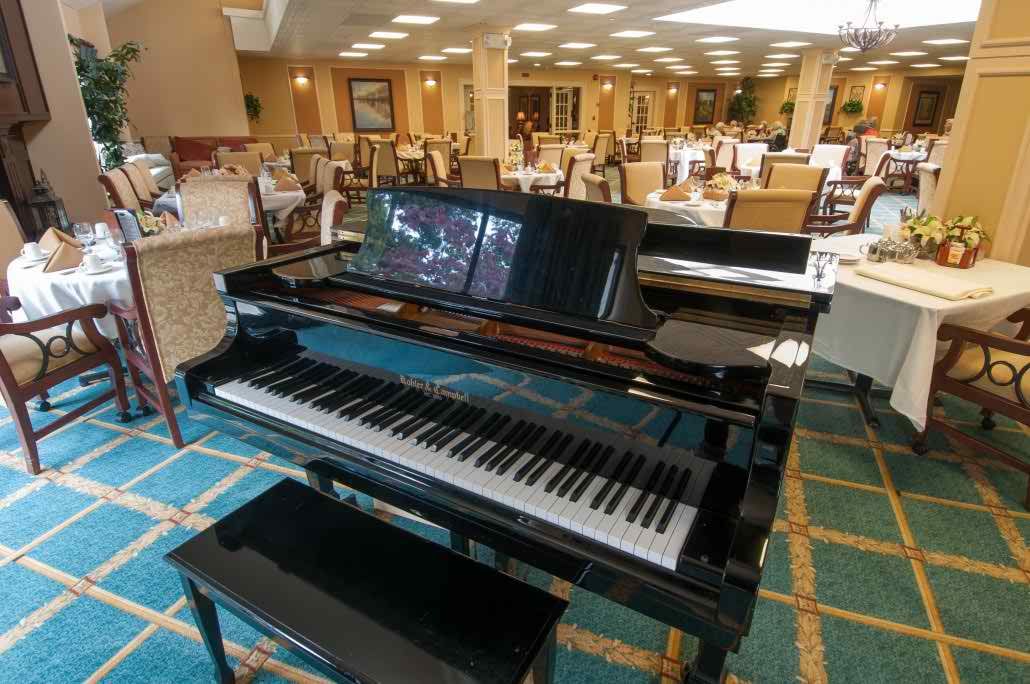 A grand piano situated in a spacious hotel lobby with elegant furnishings.