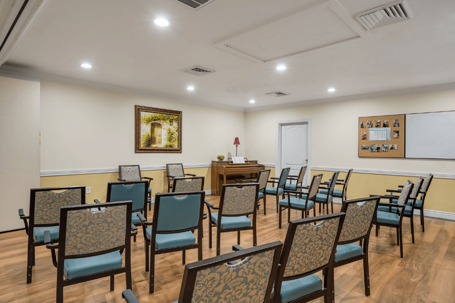 An empty meeting room with rows of chairs arranged for a gathering.