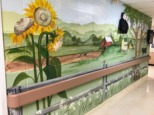A vibrant mural depicting sunflowers and a serene countryside landscape.