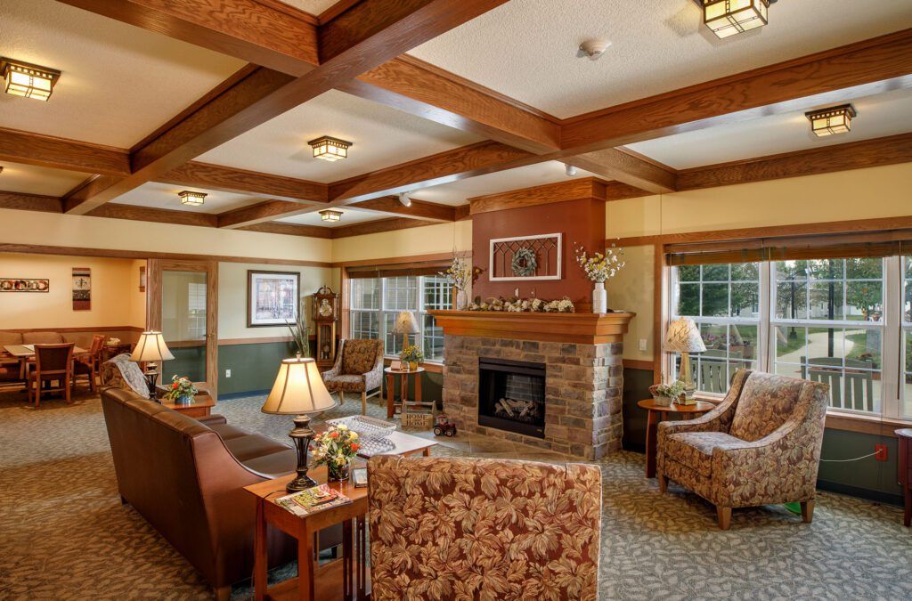 A cozy living room with a stone fireplace, wooden beams, and comfortable seating.