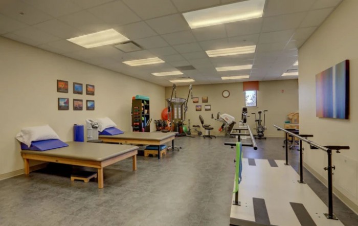 A physical therapy clinic with therapy tables and exercise equipment.