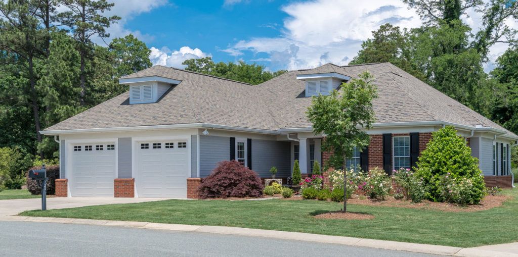 A beautiful suburban home with a well-maintained lawn and landscaping.
