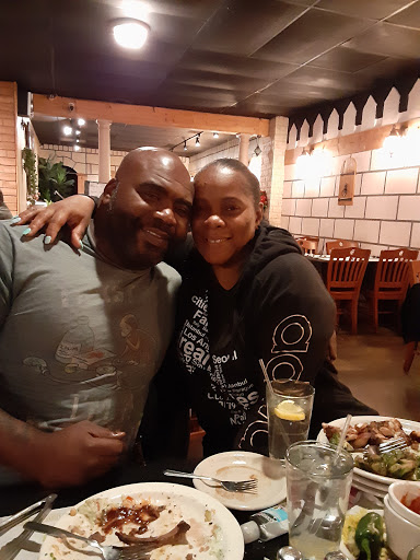 A joyful couple enjoying dinner together at a cozy restaurant.