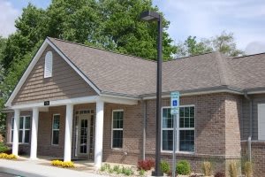A small brick office building with a front entrance and windows.