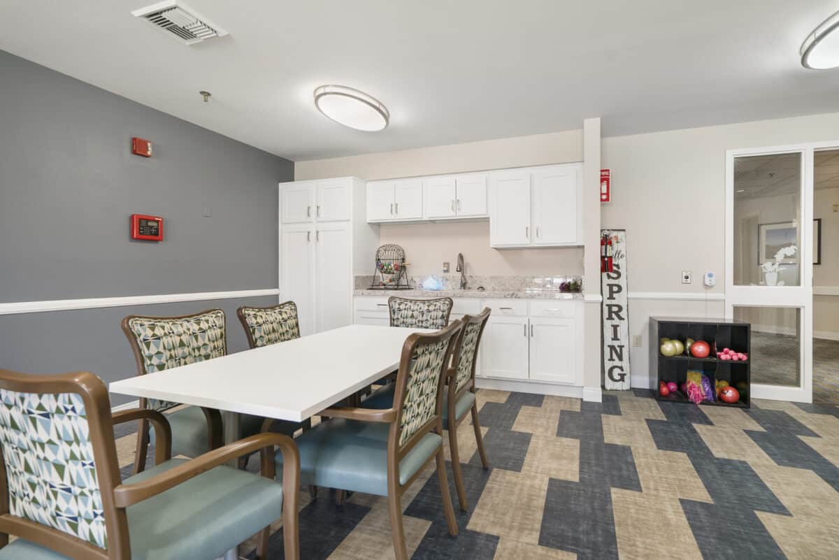 A modern kitchen and dining area with a table and chairs, featuring contemporary cabinetry and decor.