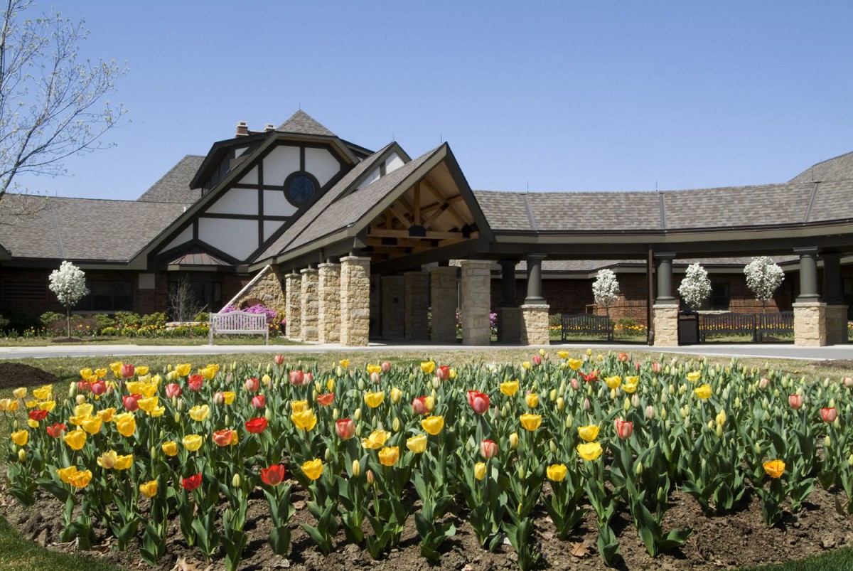 A beautifully landscaped garden with vibrant tulips in front of a charming building.
