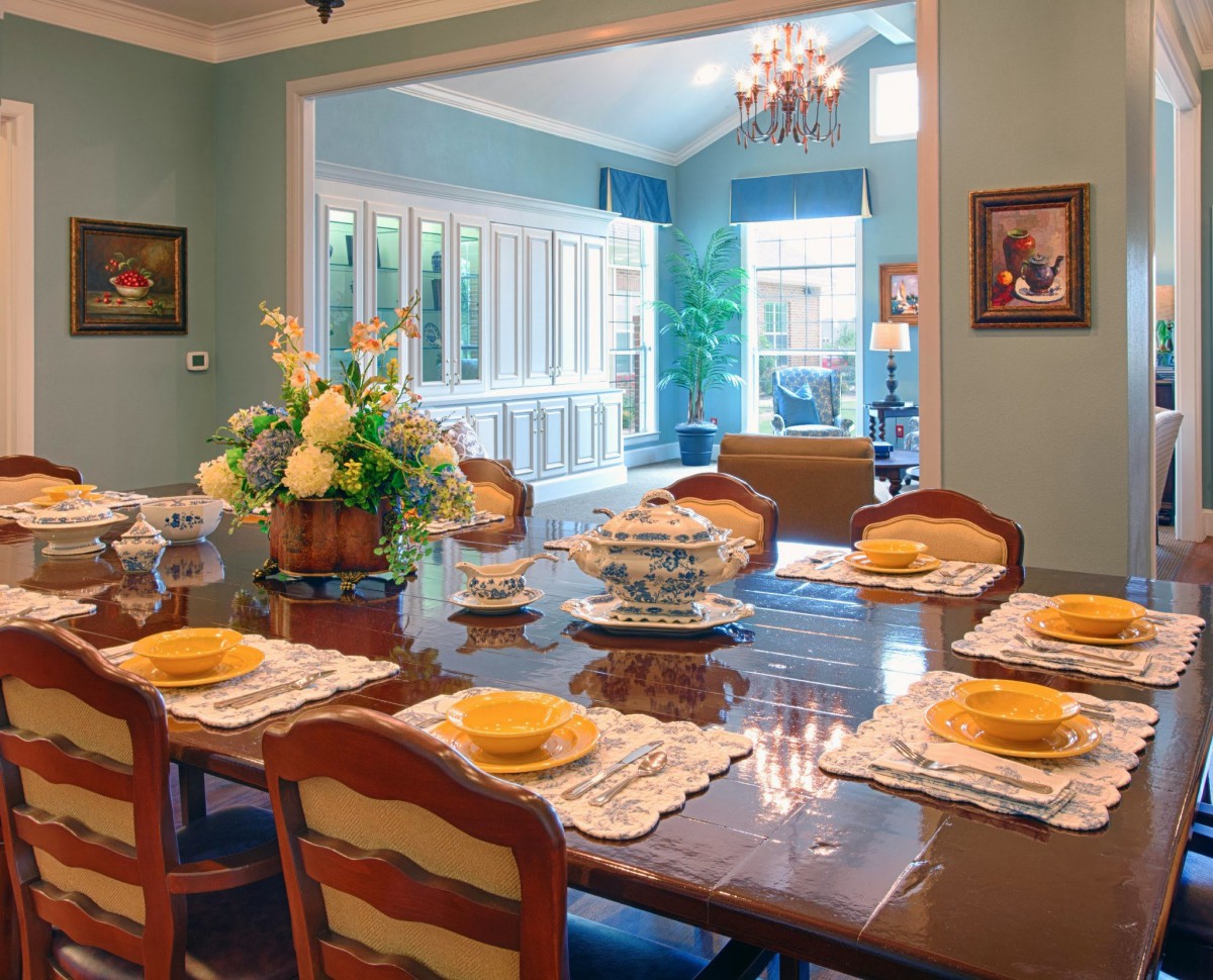 A beautifully set dining room with elegant decor and a view into a bright, inviting living space.