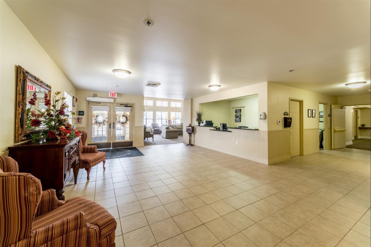 Spacious hotel lobby with reception desk and seating area.
