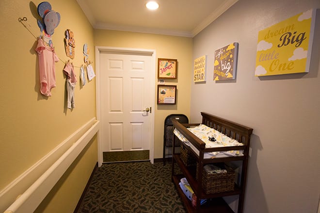 A cozy baby changing area with a decorated wall and essentials.
