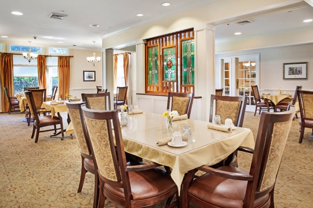 An elegantly decorated dining room with neatly arranged tables and chairs.