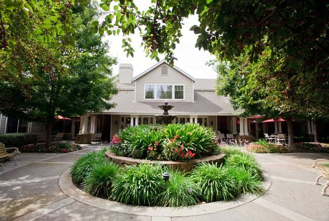 A charming house surrounded by a beautifully landscaped garden and trees.