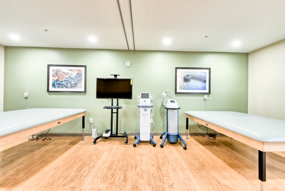 A therapy room featuring medical equipment and two treatment tables.