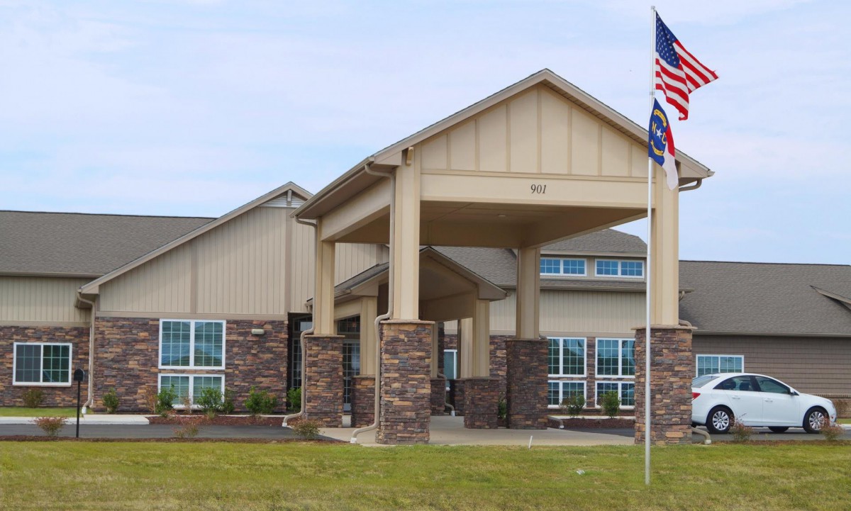 A modern building with a prominent entrance and an American flag.