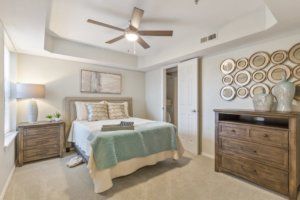 Modern bedroom interior with stylish decor and a ceiling fan.