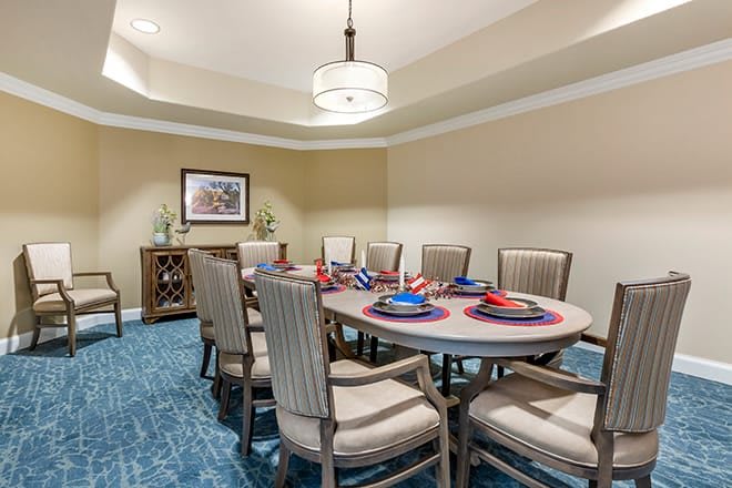 A beautifully arranged dining room featuring a set table with elegant place settings and comfortable chairs.