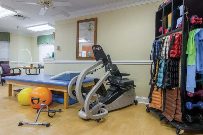 A rehabilitation room equipped with various exercise machines and therapy tools.